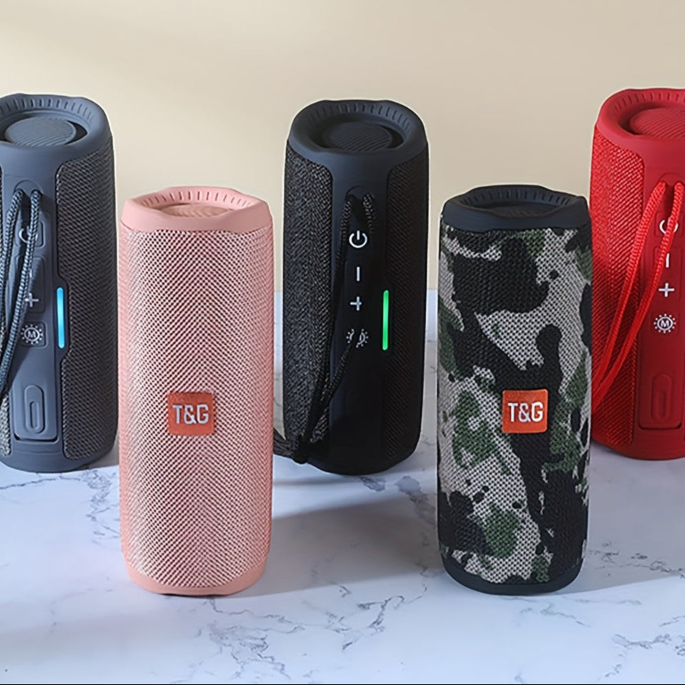 Five portable speakers in different colors and designs on a marble surface.