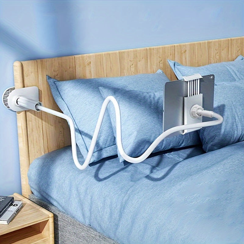 Bedside tablet holder on a bed with blue bedding and wooden headboard