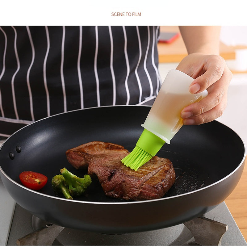 Person cooking steak in a pan with a green brush applying oil, wearing a striped apron.