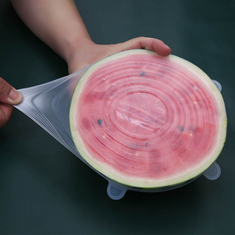 Half of a watermelon with a silicone lid on a dark background