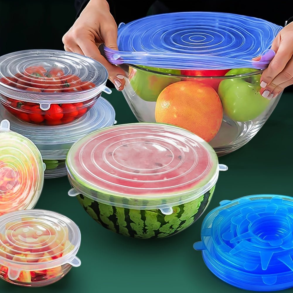 Clear bowls with colorful silicone lids on a green background