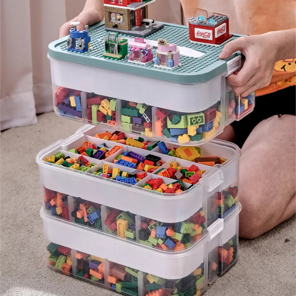 Stackable toy storage bins filled with colorful building blocks, held by a person.