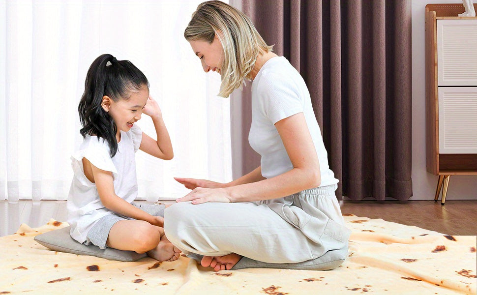 Woman and young girl sitting on the floor in a room with curtains and furniture.