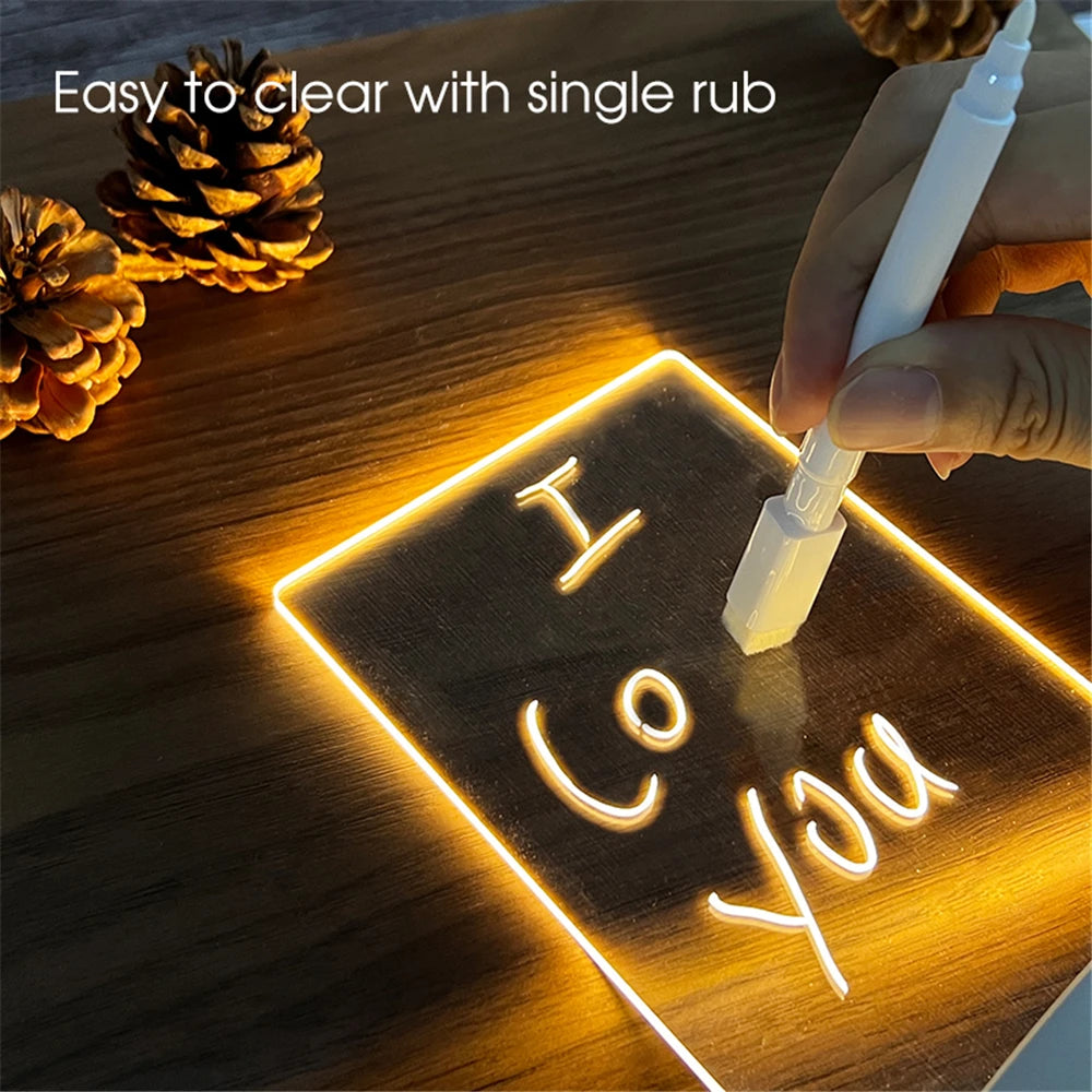 Handwriting on a glowing surface with a pen, surrounded by pine cones.