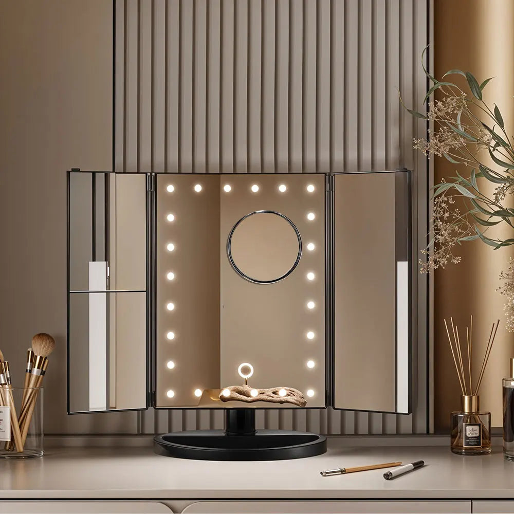 Makeup mirror with lights on a vanity table with makeup items.