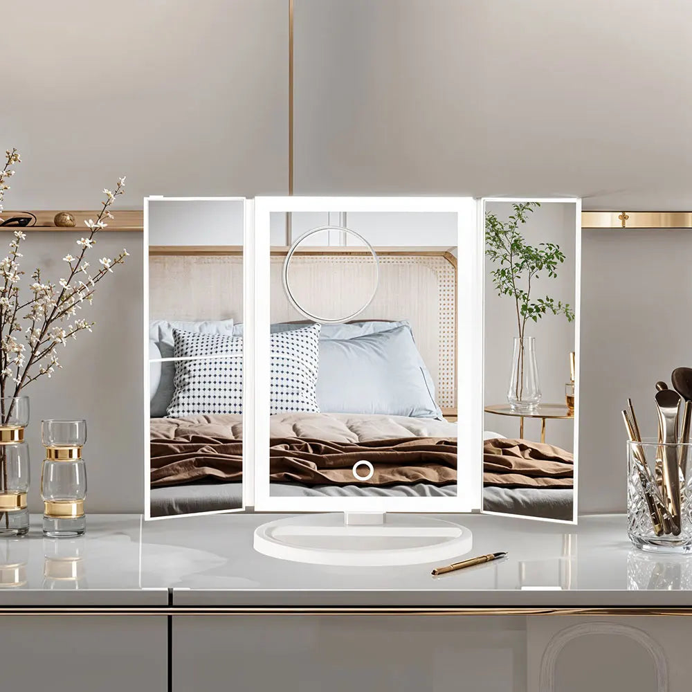 Makeup mirror with LED lights on a vanity table with decorative items.