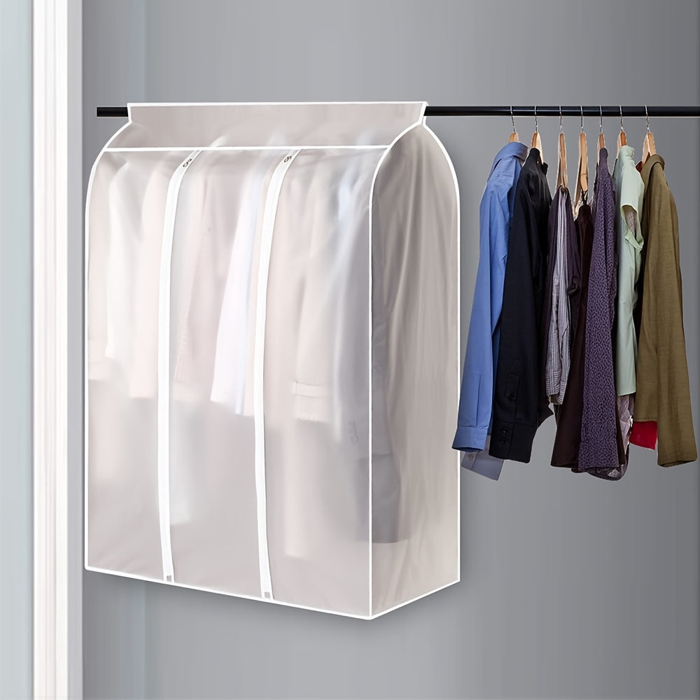 Clear garment bag with clothes hanging inside on a gray background