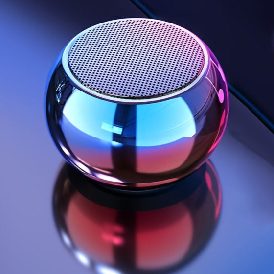 Metallic reflective speaker on a reflective surface with a dark background