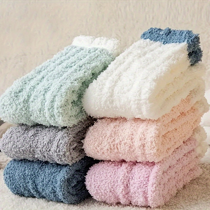 Stack of soft, textured socks in various colors on a neutral background