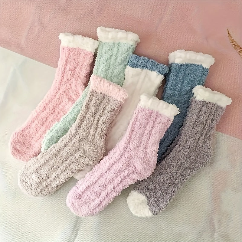 Set of colorful fluffy socks on a light pink background