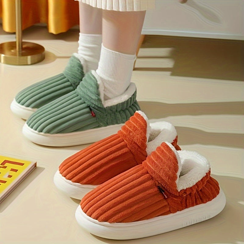 Green and orange slippers on a light-colored floor.