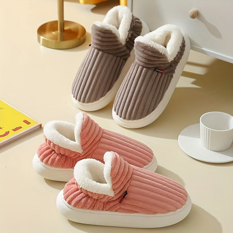 Pair of brown and pink slippers on a light surface with a cup and saucer in the background.