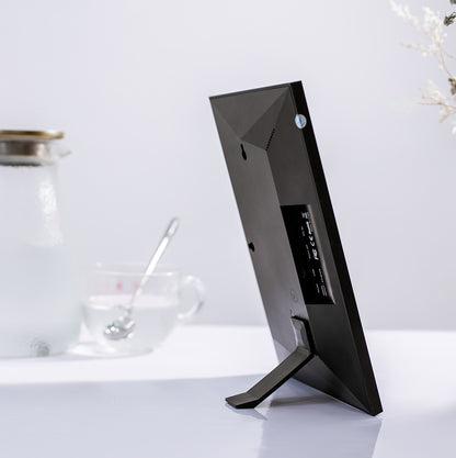 Black computer monitor on a white surface with a blurred background
