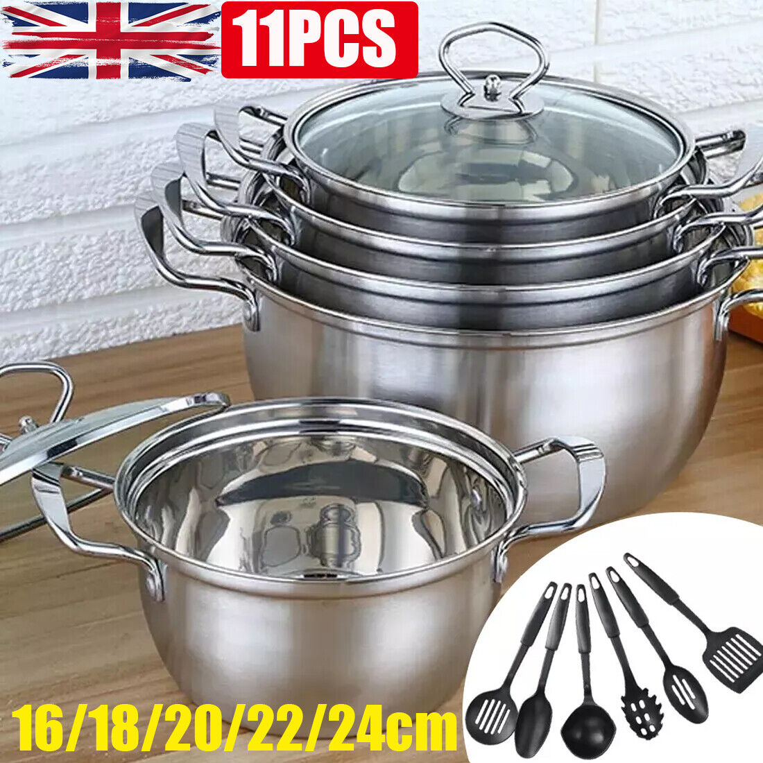 Set of stainless steel pots and lids with additional utensils on a wooden surface.