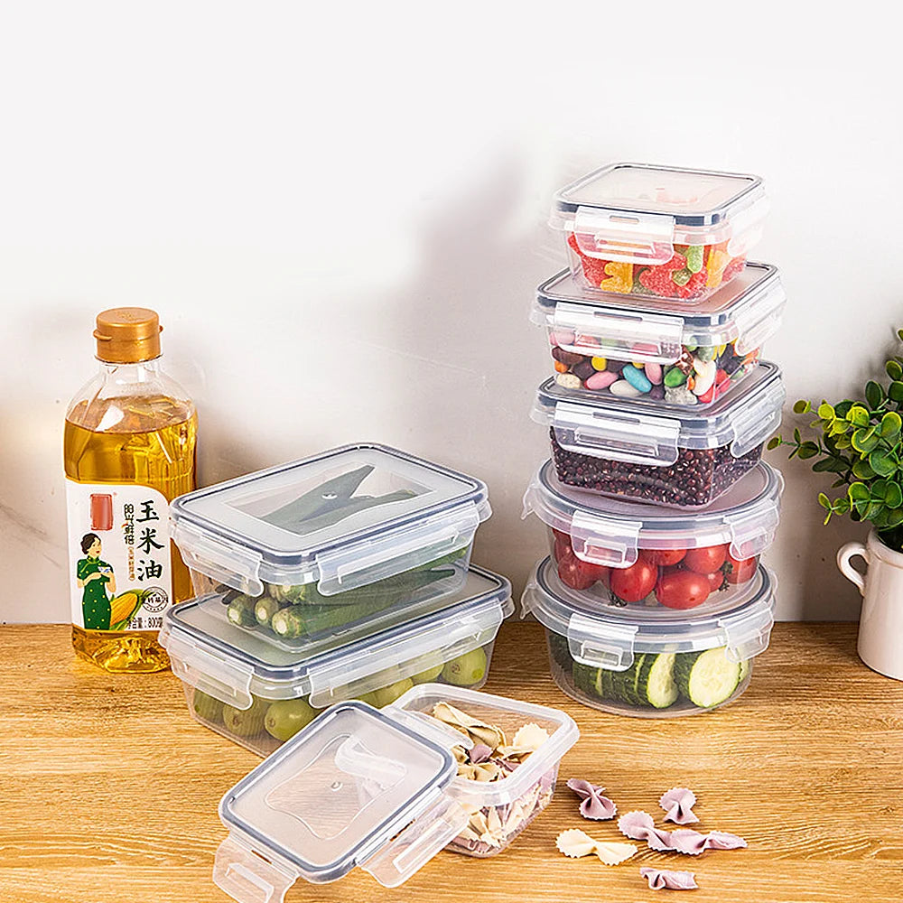 Set of clear food storage containers with various foods on a wooden surface.