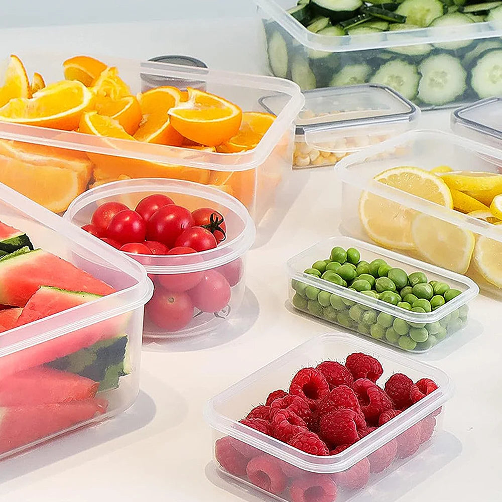 Assorted fruits and vegetables in clear containers on a white surface
