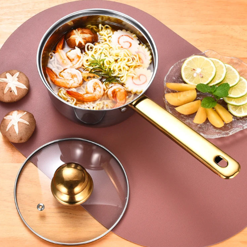 Stir-fry pan with noodles and seafood on a wooden surface with fruits and vegetables.