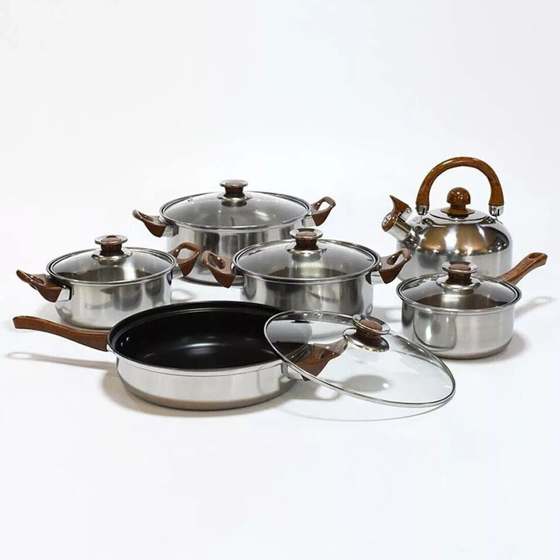 Set of stainless steel cookware with wooden handles on a white background