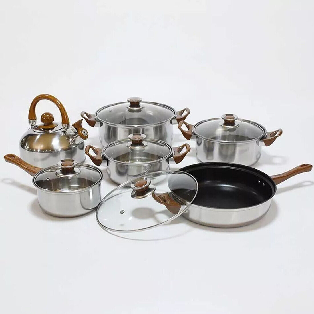 Set of cookware including pots, pans, and lids on a white background