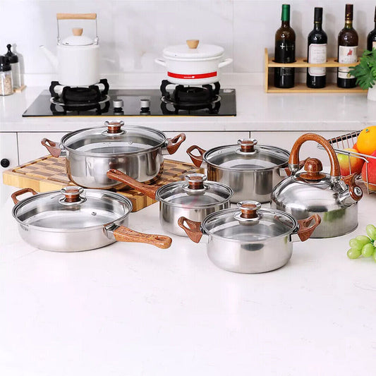 Set of stainless steel cookware on a kitchen counter with a stove and bottles in the background.
