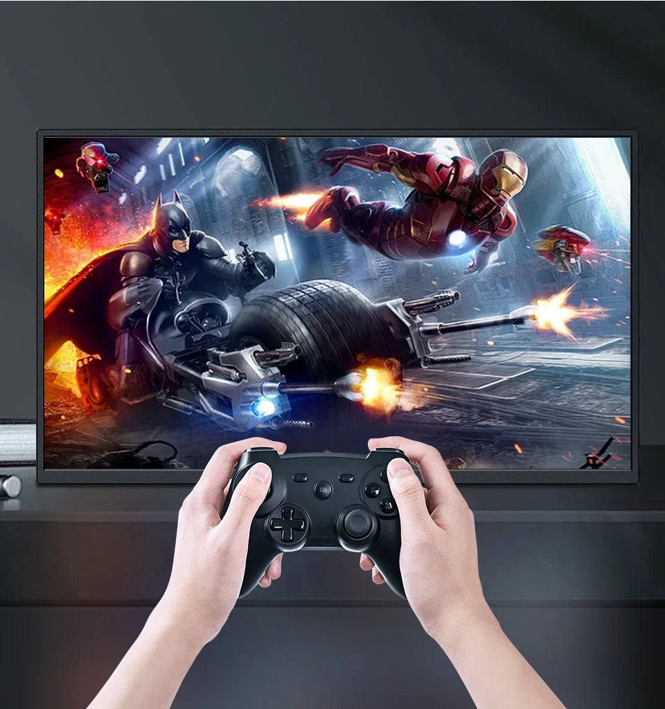 Person playing a video game with a controller in front of a screen displaying superhero action.