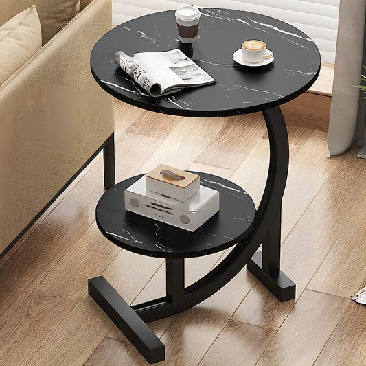 Black marble-patterned side table with a newspaper, coffee cups, and small items in a living room setting.