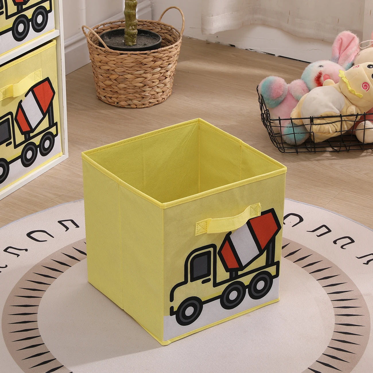 Yellow storage bin with a cement truck design on a wooden floor.