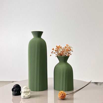 Two green textured vases on a white surface with a plain background