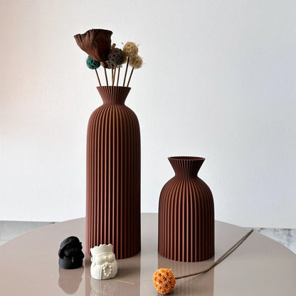 Two brown textured vases on a light surface with a white background
