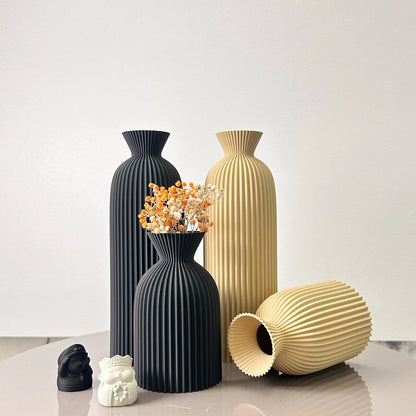 Set of black and beige vases on a light surface with a white background