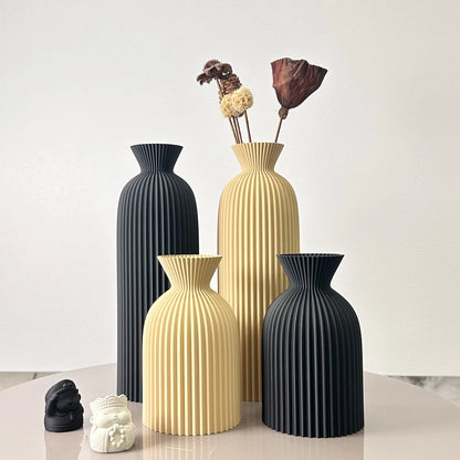 Set of four decorative vases in black and beige on a light surface with a white background