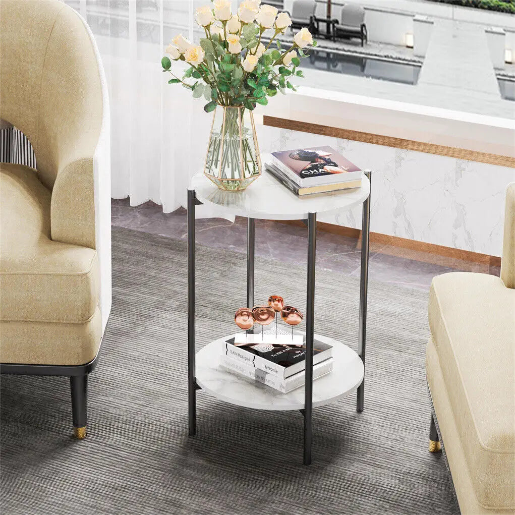Small round side table with a vase of flowers and books in a living room setting.