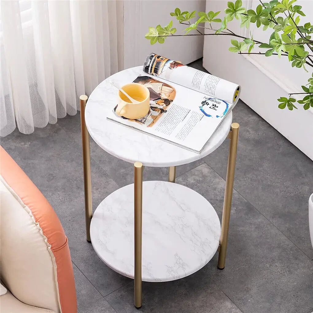Round marble side table with gold legs in a living room setting.