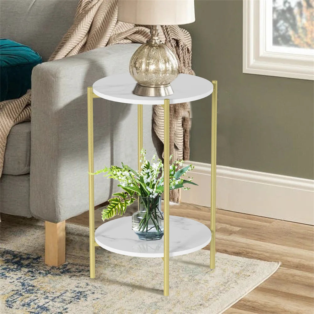 Small round side table with gold legs and white marble top in a living room setting.
