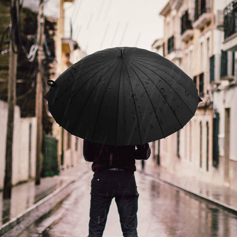 Man Holding Large Black Umbrella in the Rain