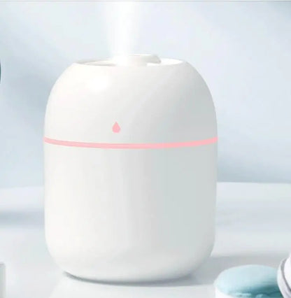 White humidifier with a pink light on a light blue background