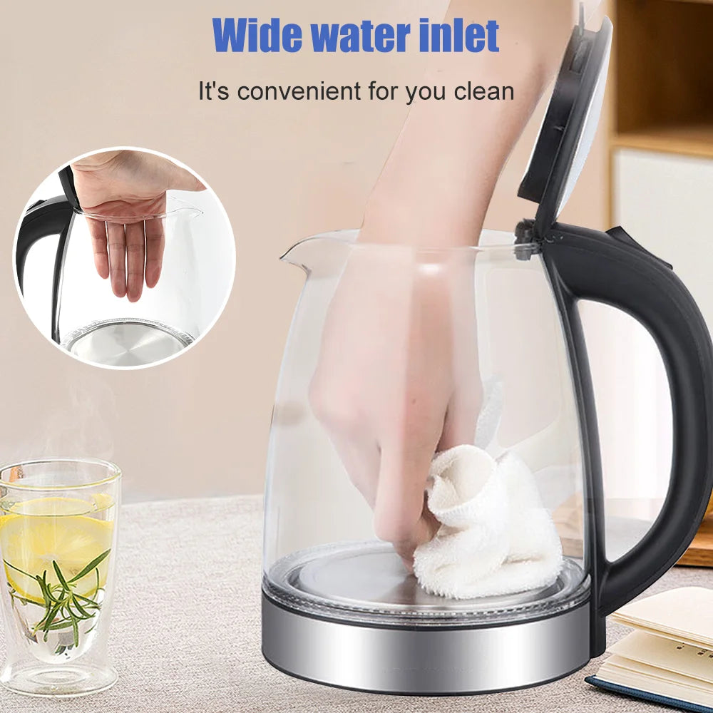 Clear glass electric kettle with black handle on a light surface, featuring text about wide water inlet.