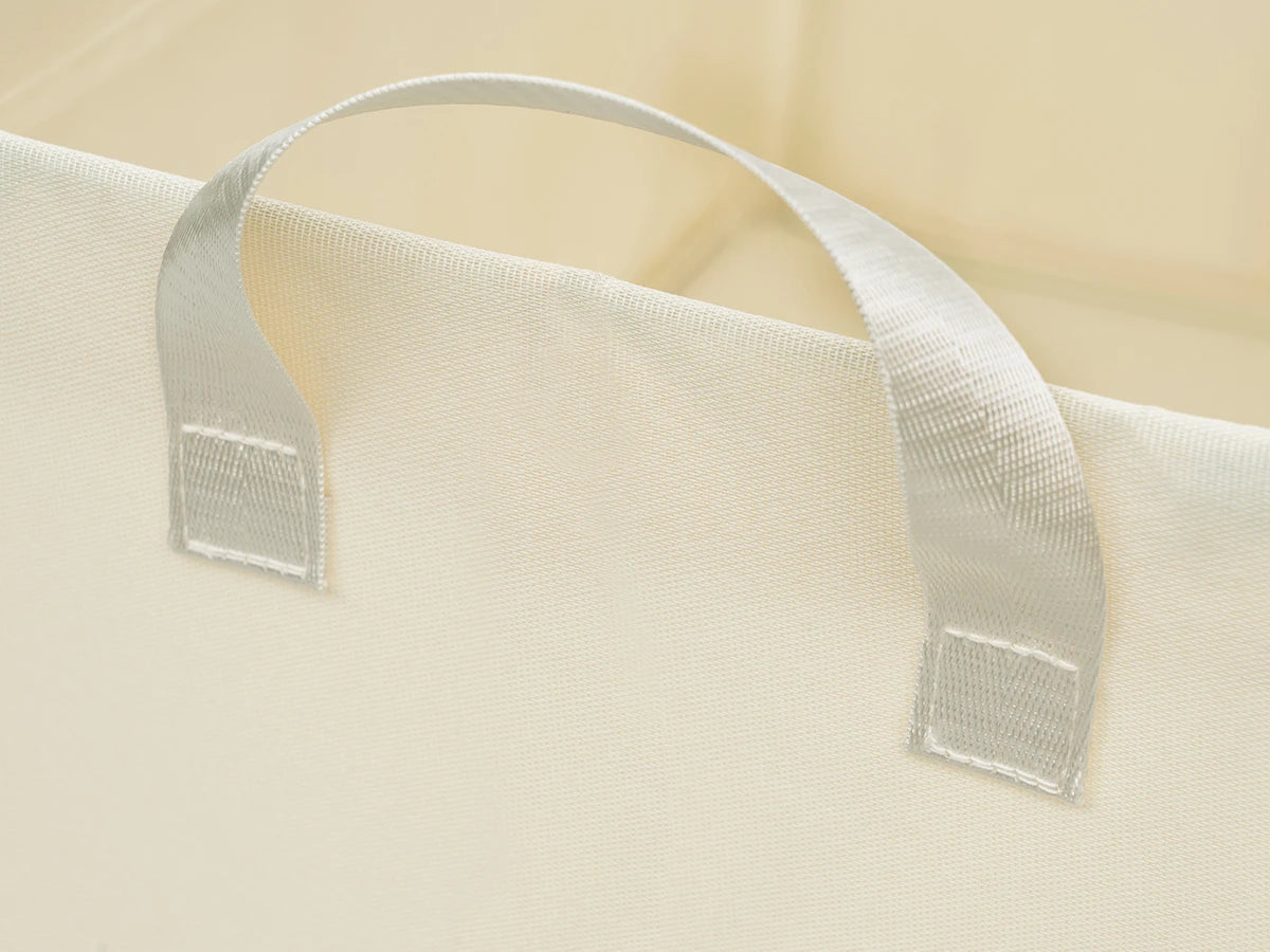 Close-up of a beige fabric with a white strap and mesh patch on a beige background