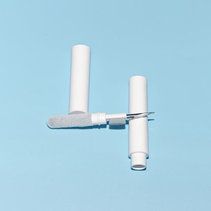 White cleaning tool with a brush and handle on a light blue background