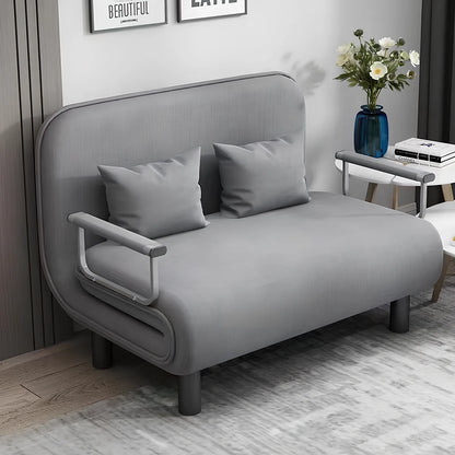 Gray sofa bed in a room with a small table and decorative items.