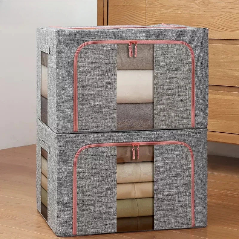 Two gray storage cubes with pink zippers stacked on a wooden surface.