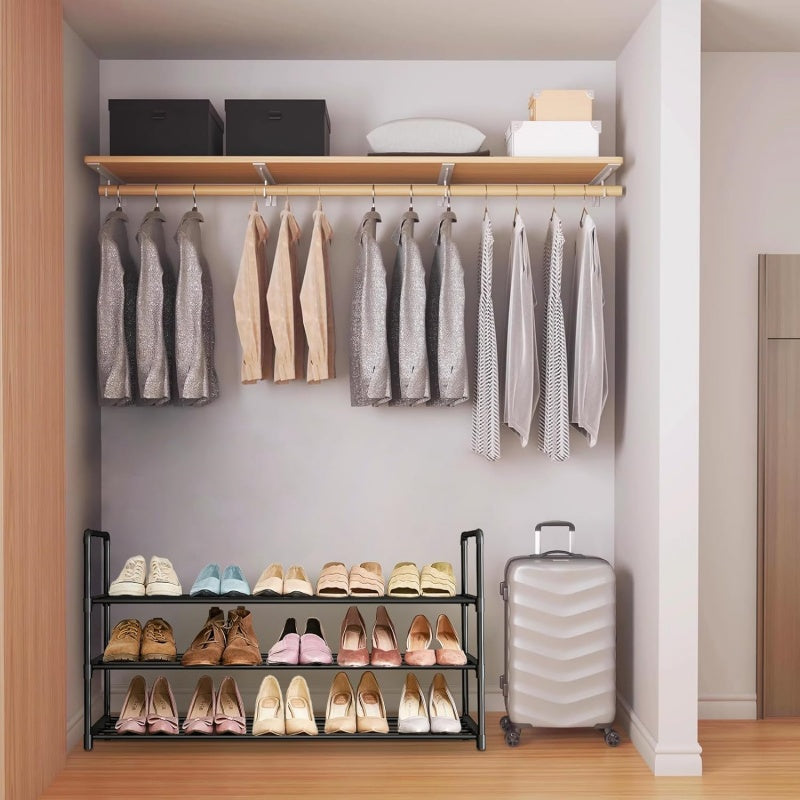 Closet with hanging clothes, shoes on shelves, and a suitcase.