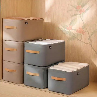 Set of storage boxes with lids on a wooden floor against a floral-patterned wall.