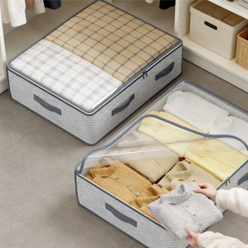 Two striped fabric storage bins with clear zippered lids are shown in a closet setting. One bin is closed and filled with folded clothes, and another bin is open with a person's hands placing a folded garment inside.