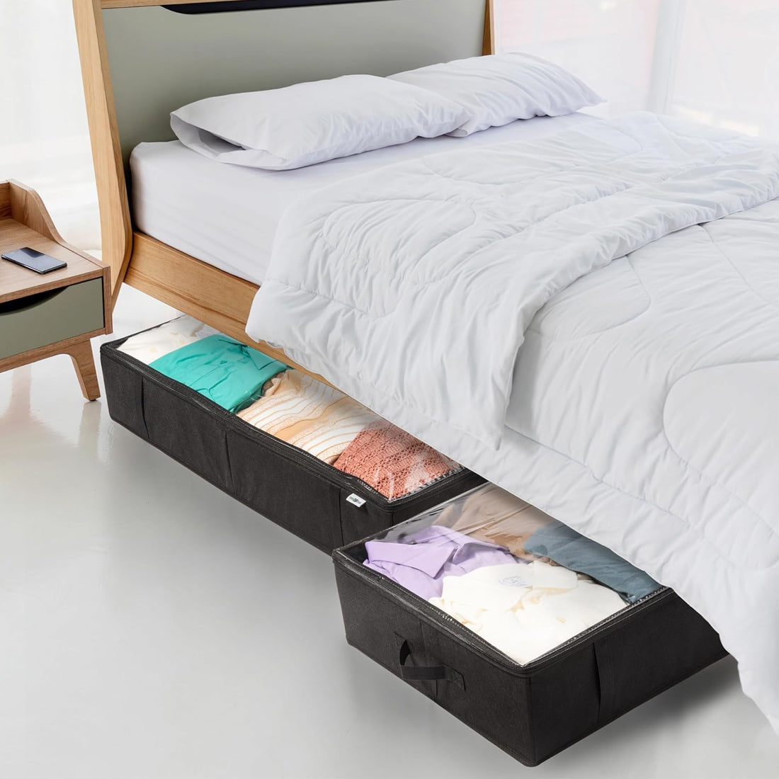 Underbed storage drawers with clothes underneath a bed in a bedroom setting.