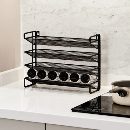 Black mesh spice rack on a kitchen counter with a marble wall background