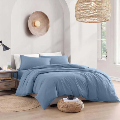 Blue bedding set on a bed in a bedroom with wicker lampshades and decor.