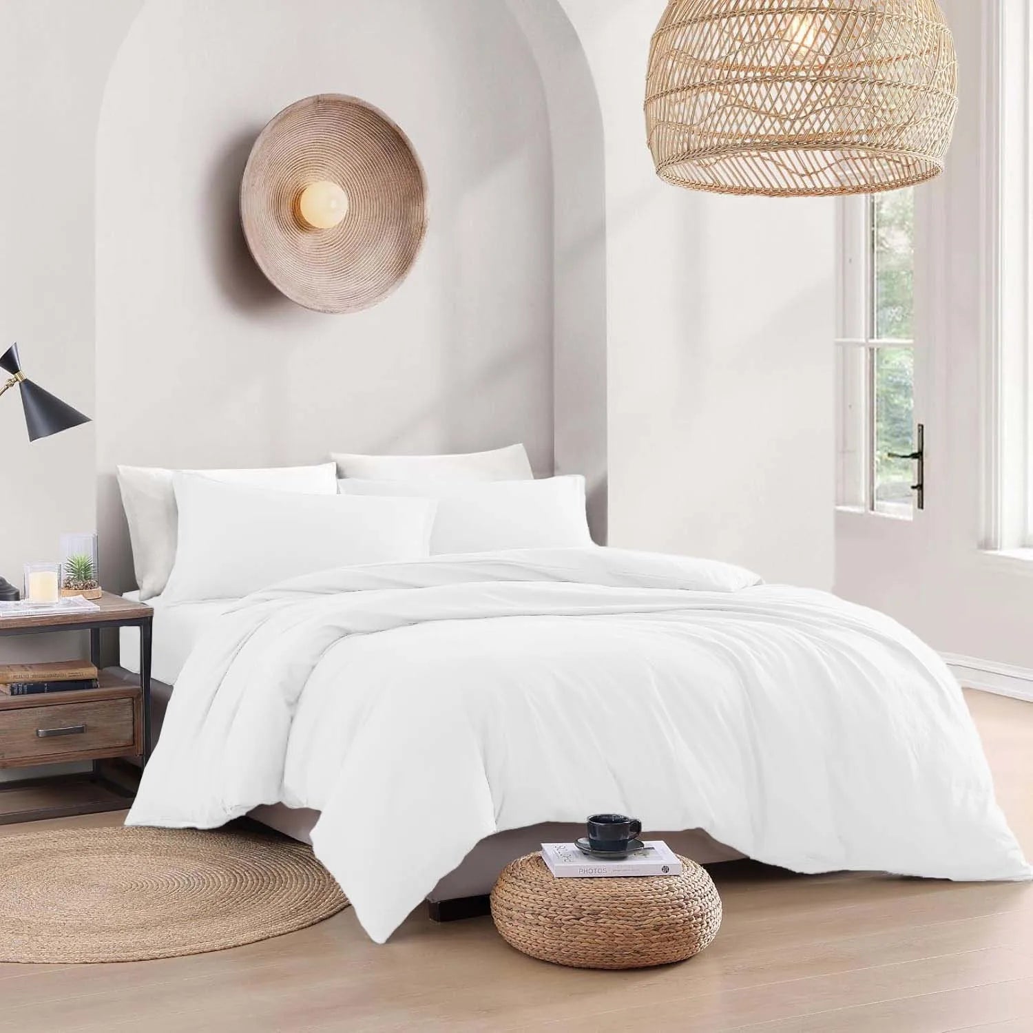 White bedding set on a bed in a modern bedroom with wooden floors and decorative lamps.