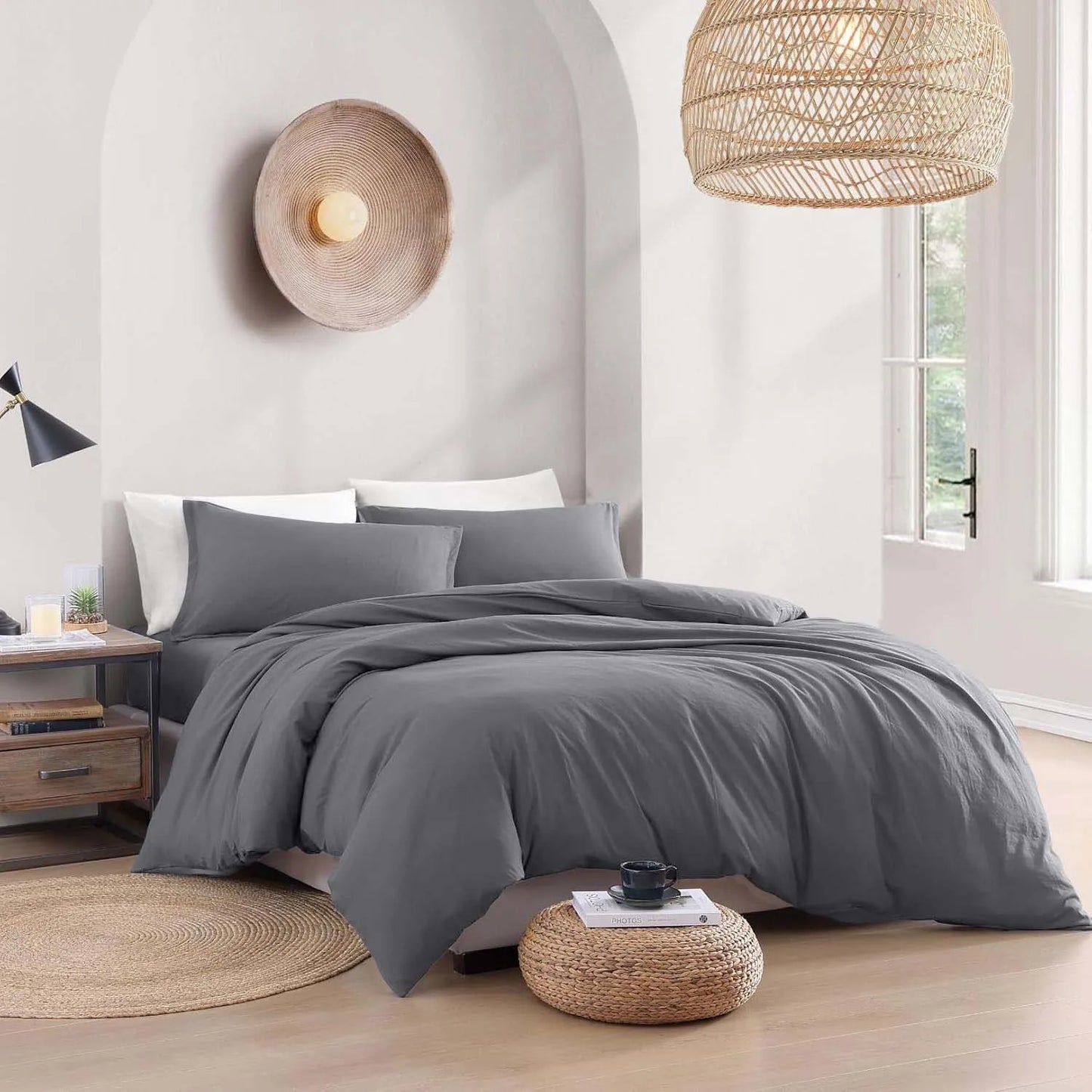 Gray bedding set on a bed in a modern bedroom with wooden floors and decorative lamps.