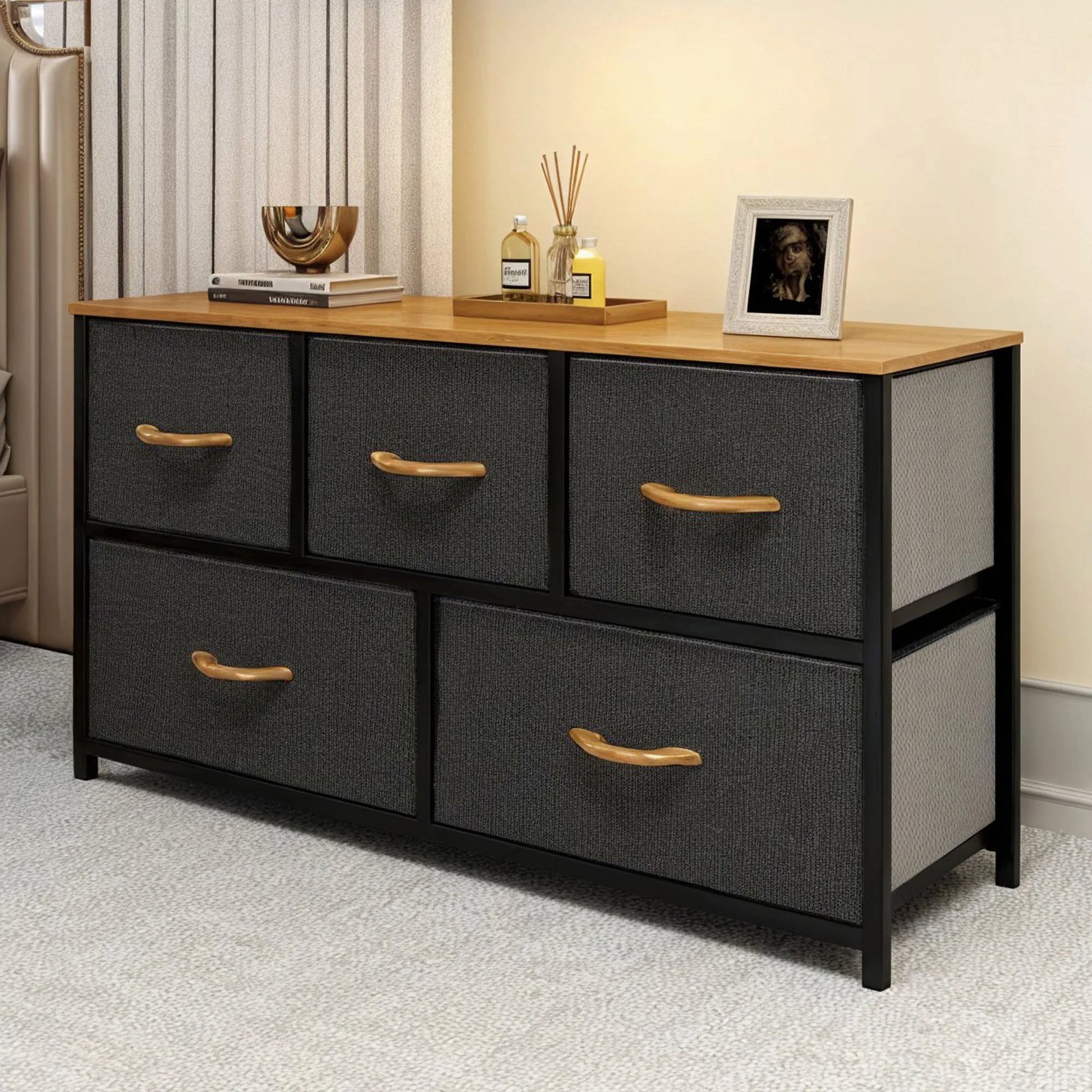 Wooden dresser with gray fabric drawers and wooden handles in a room setting.